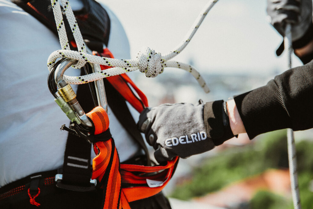 a person wearing a harness and holding a rope